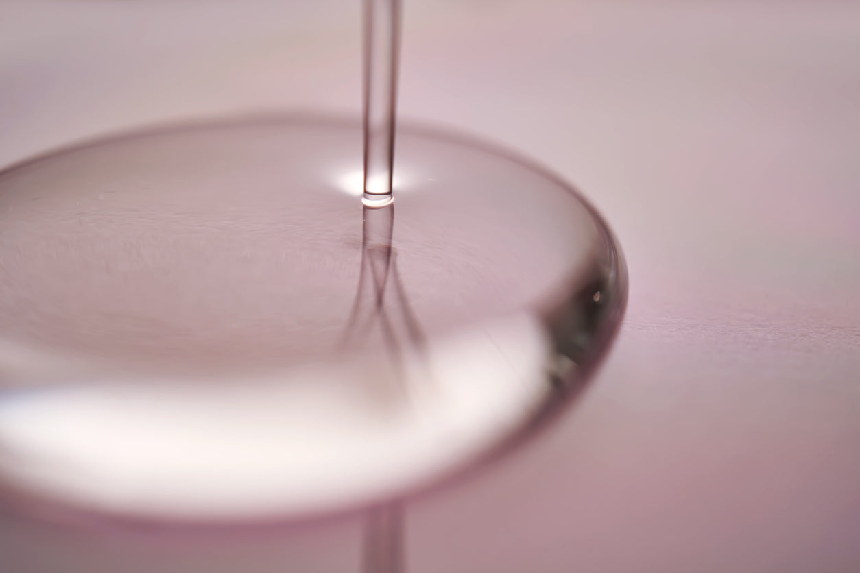 a droplet of clear gel on a lavender color background