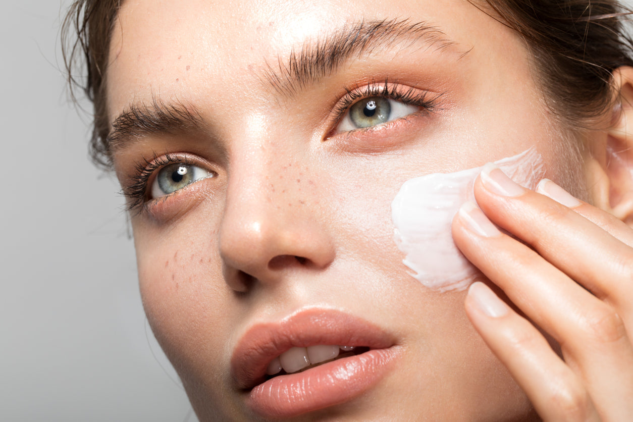 young female model applying organic tightening creme glaze face cream