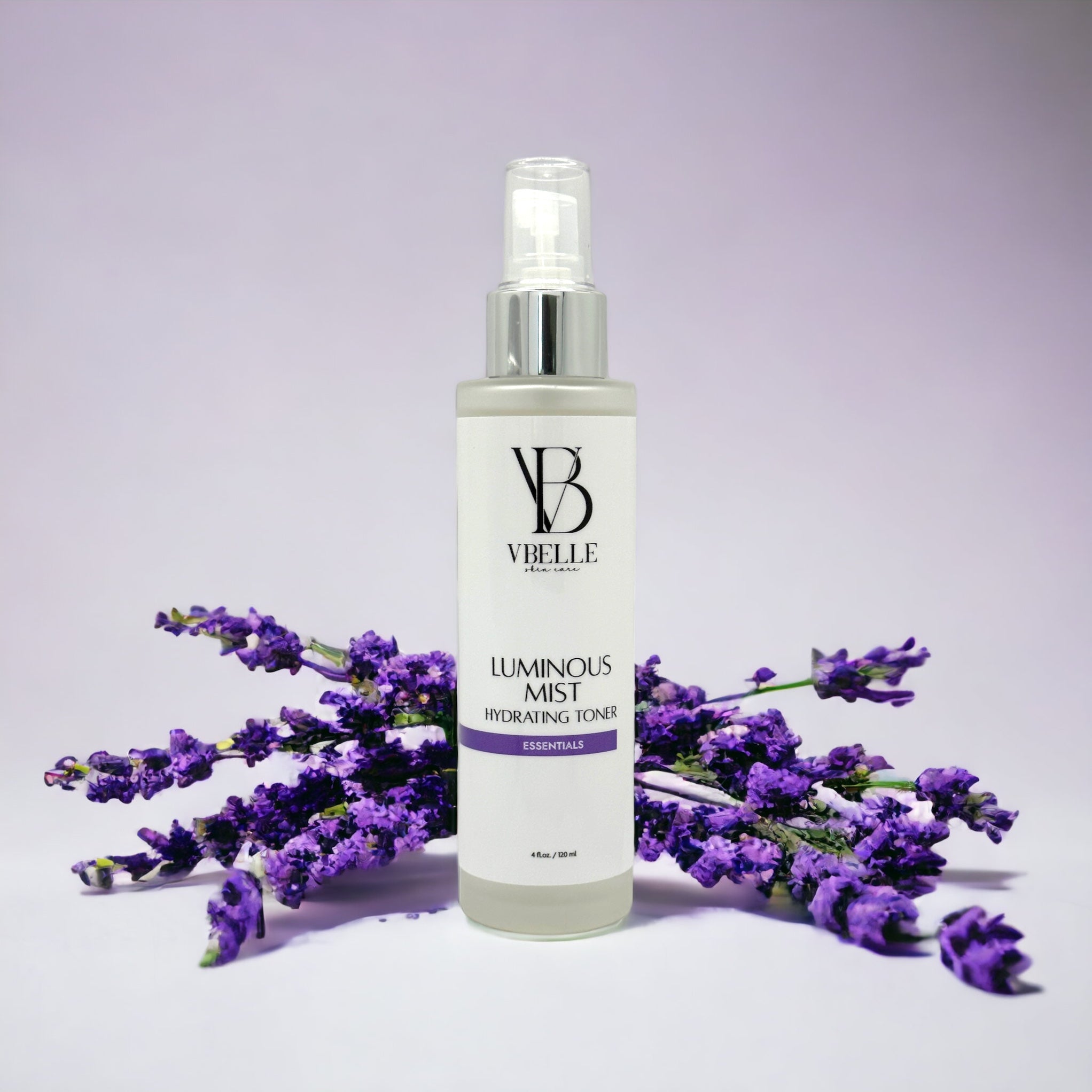 Organic Luminous Mist Hydrating Toner  4 fl oz glass bottle with Lavender flowers in the background and a light violet backdrop