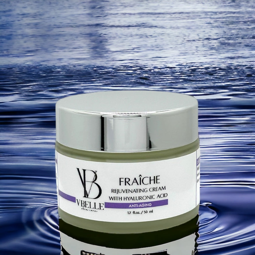 Organic fraiche rejuvenating face cream with hyaluronic acid in a 1.7 fl oz jar on a water background with a reflection