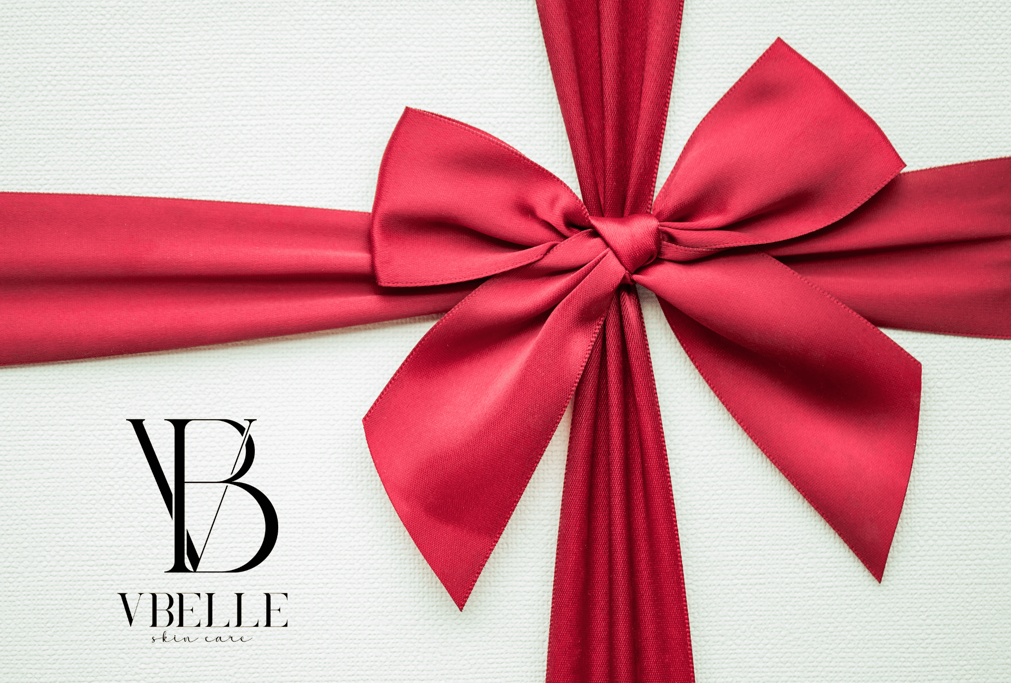 white gift card with a red bow and Vbelle Skin Care logo on it